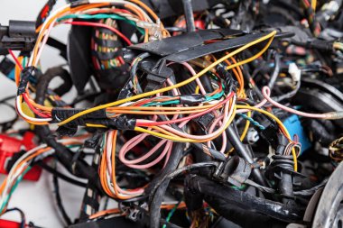 Çok renkli kablolardan oluşan elektrik ağı: sarı, kırmızı ve yeşil, kablo bobinlerinin arka planında siyah elektrik bandıyla geri sarma.