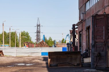 Elektrik hatlarının ve eski demiryolunun arkasındaki sanayi deposu. Demir parçaları ve ekipmanların depolandığı bölgede terk edilmiş bir fabrika..