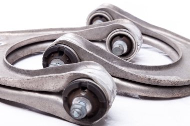 Bir çift metal şasi kolu, top ve çalılıklı plastik metal menteşeli yakın plan. Fotoğraf stüdyosundaki beyaz arka planda sessiz bloklar. Atölyede askıya alınan rmont için yedek parça