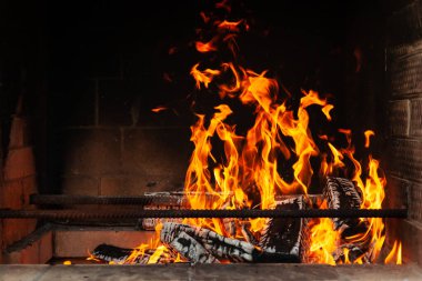 Tuğlalı, dumanlı bir barbekü sobası. Kırsal kesimde bir yaz haftasonu kömürleşmiş odun odunlarından çıkan alevli şişler için demir çubuklar..