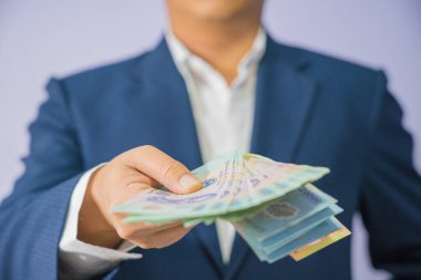 Vietnam 'da para mavi bir takım elbise giyen el iş adam tutun (Vietnam Sosyalist Cumhuriyeti), Dong, VND, ödeme, beyaz arka planda Vietnamlı döviz para.