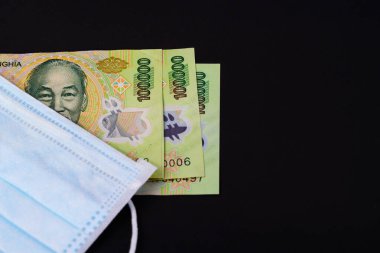 Vietnam Dong 'da para, VND Vietnamlı maskeli sağlık görevlisi kulak iltihabı ameliyatı ile karşı karşıya, insanlar sağlığına dikkat etsin ve koronavirüs hastalığını COVID-19 ve SMOG dumanı siyah arka planda PM2.5.