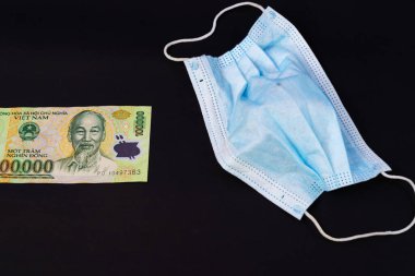 Vietnam Dong 'da para, VND Vietnamlı maskeli sağlık görevlisi kulak iltihabı ameliyatı ile karşı karşıya, insanlar sağlığına dikkat etsin ve koronavirüs hastalığını COVID-19 ve SMOG dumanı siyah arka planda PM2.5.