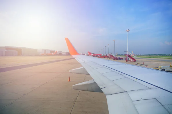 Private aviation view from inside window Airplane airliner aircraft The plane is parking bay on Terminal runway while waiting Compartment and Hangar background Sunlight and flare in BANGKOK THAILAND