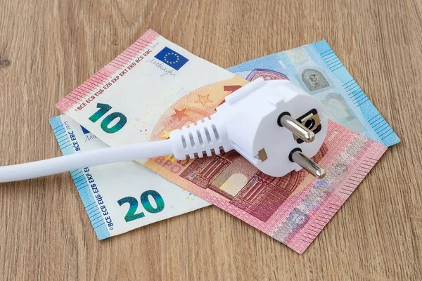 Kahverengi ahşap bir yüzey üzerinde euro banknotlarının beyaz elektrik prizi. 