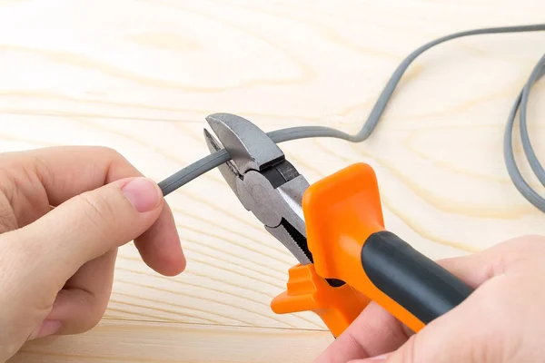 Woman hand holding a metall side cutters and cutting a wire. — Stock Photo, Image