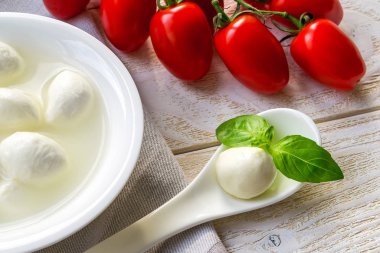 Mini mozzarella peynir topu ve fesleğenin yakın çekimi..