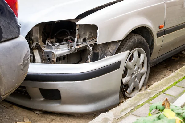 Stationary car without a headlight and with a fallen off bumper. — Stock Photo, Image