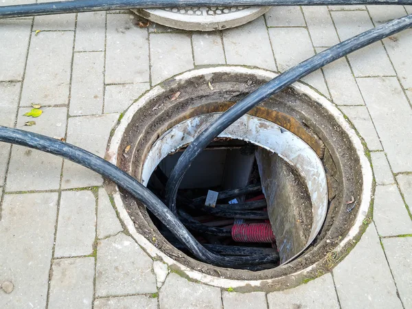 Geöffneter Schacht für Kabelwechsel auf dem Gehweg. — Stockfoto