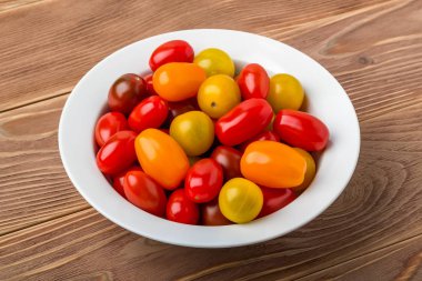 Beyaz bir porselen kasede çok renkli kiraz domatesleri