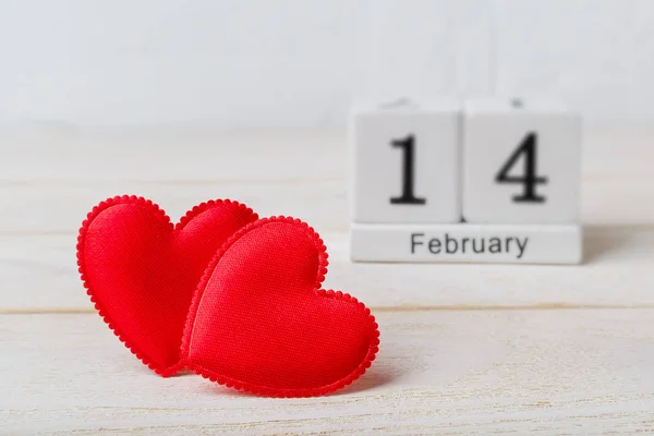 Two red silk valentine hearts and wooden calendar with 14 february — Stock Photo, Image