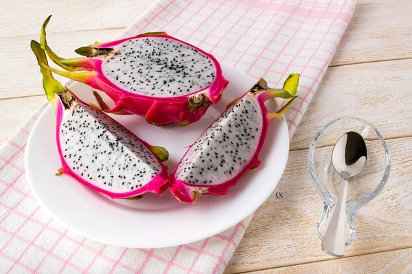 Cut into three parts dragon fruit or pitaya on a plate.