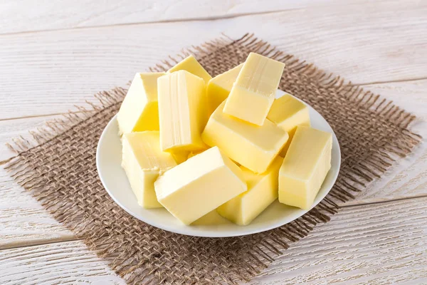 Rectangular pieces of fresh yellow butter on a white saucer