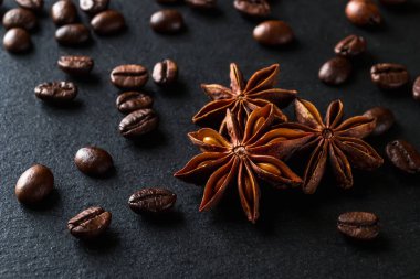 Three star anise and roasted coffee beans on stone surface