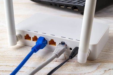 Beyaz bir Wi-Fi yönlendiricisine bağlı ağ kablolarını kapat