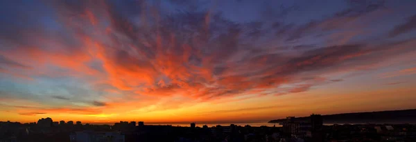 Panorama del fuego del amanecer en el cielo sobre una pequeña ciudad costera . — Foto de Stock