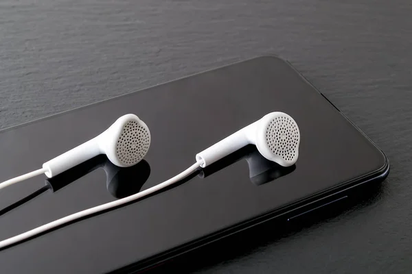 White Earphones Reflects Black Smartphone Screen Black Stone Surface Modern — Stock Photo, Image