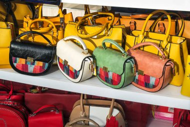 Varna, Bulgaristan, 27 Mart 2020. Güneşli bir bahar gününde bir tuhafiyecinin vitrininde modern moda çok renkli deri çantalar.. 