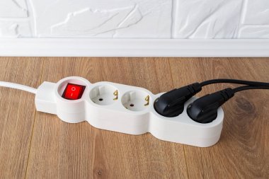 Güç düğmeli beyaz uzatma kablosu ve yerde dört priz. Ev ya da ofis anahtarı olan elektrik kablosu. Ev aletleri. Üst görünüm.