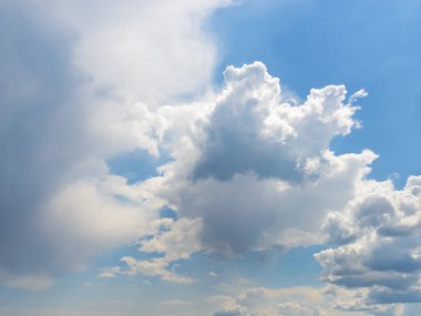 Beyaz tüylü kümülüs bulutları güneşli bir günde mavi gökyüzünde yavaş yavaş yüzüyor. Meteoroloji, hava durumu ve farklı bulut türleri. Düşük açı görünümü.