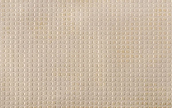 Beige faux leather with a pattern of evenly repeating small circles. A variety of textures of artificial materials. Background. Top view.