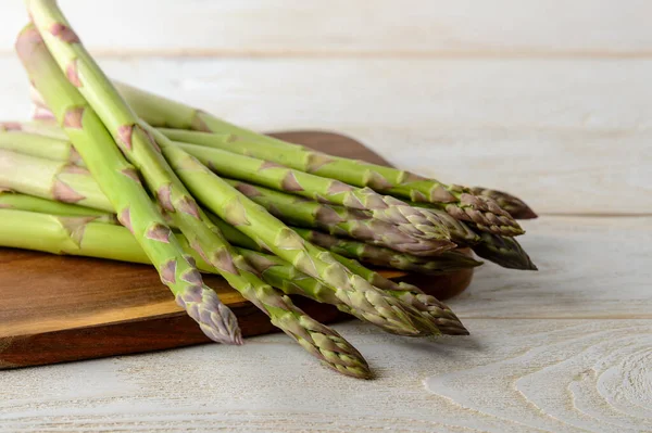 Raw Fresh Green Asparagus Stalks Brown Cutting Board White Wood — Stock Photo, Image