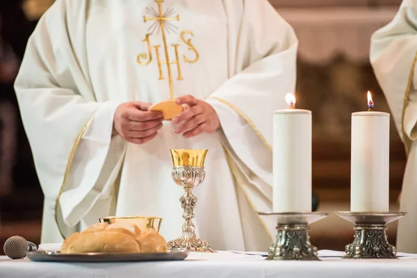 在天主教弥撒期间圣餐仪式上展示圣饼的牧师 — 图库照片