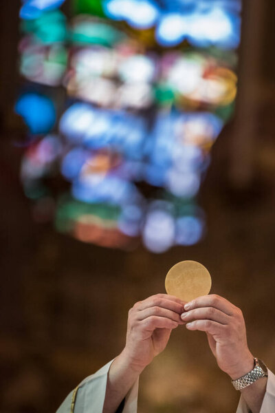 Minister showing the holy bread during the rite of the Holy Communion during the catholic mass