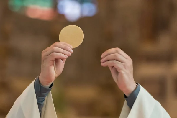 Minister Ukazujący Święty Chleb Podczas Obrzędu Komunii Podczas Mszy Katolickiej — Zdjęcie stockowe