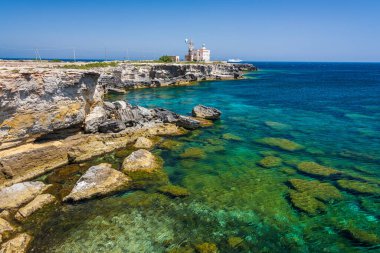 Sicilya, Aegadian Adaları, Favignana 'daki deniz feneriyle Cala Azzurra' nın şeffaf kaynayan suyu.