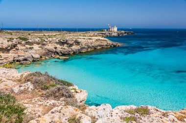 Sicilya, Aegadian Adaları, Favignana 'daki deniz feneriyle Cala Azzurra' nın şeffaf kaynayan suyu.