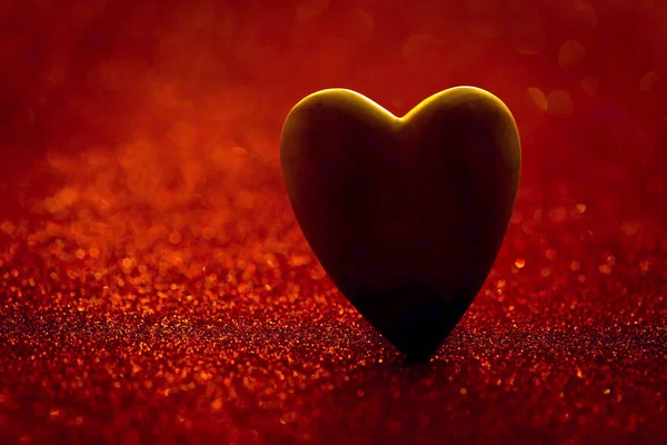 Corazón de madera sobre un fondo rojo borroso — Foto de Stock