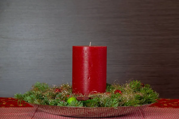 緑のトウヒの装飾と茶色の前のクリスマス球根と赤いキャンドルテキストのためのコピースペースを持つ背景 — ストック写真