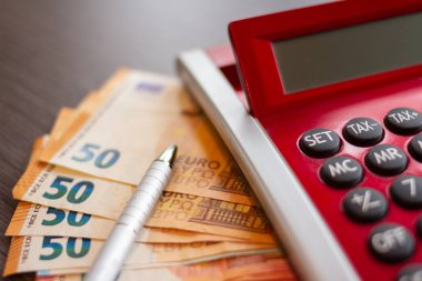 Bütçe Planlama Konsepti. Hesap makinesi, Avro para birimi banknotları ve merkez ofisteki masada bir kalem.