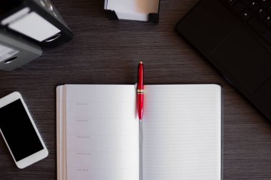 Laptop, akıllı telefon, defter ve diğer malzemelerle modern ofis masası. Belgeler ve dijital cihazlarla ofis kavramı. Yeni yenilikçi Teknoloji ve verimli iş akışları