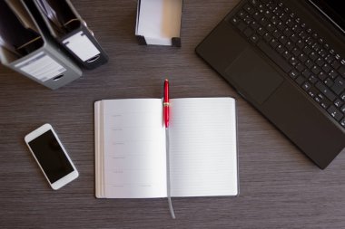 Laptop, akıllı telefon, defter ve diğer malzemelerle modern ofis masası. Belgeler ve dijital cihazlarla ofis kavramı. Yeni yenilikçi Teknoloji ve verimli iş akışları