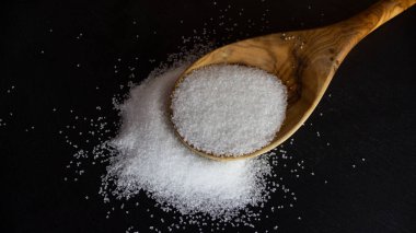 Tahta kaşıkta beyaz şeker. Beslenme Konsepti. Sağlıksız yiyecekler