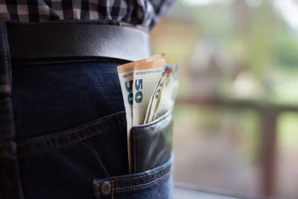 Confident business man safe keeping his wallet in the back pocket of his pants