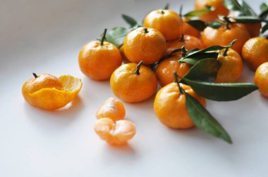 Beyaz arkaplanda yaprakları olan mandalinalar