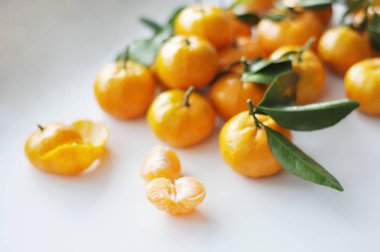 Beyaz arkaplanda yaprakları olan mandalinalar