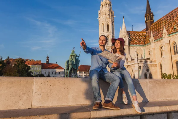 Young couple searching right direction on map from the point from Fisherman Bastion in Budapest with Matthias Church on background — Stockfoto