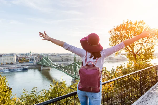 Uma jovem feliz desfrutando de sua viagem a Budapeste, Hungria a partir do ponto de Gellert Hill durante o nascer do sol no outono — Fotografia de Stock