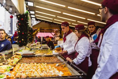 Budapeşte, Macaristan - 08 Kasım 2019: Vorosmarty Meydanı 'ndaki güzel Noel Pazarı' nın tadını çıkaran turistler ve yerel halk.