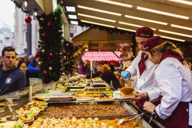 Budapeşte, Macaristan - 08 Kasım 2019: Vorosmarty Meydanı 'ndaki güzel Noel Pazarı' nın tadını çıkaran turistler ve yerel halk.