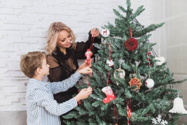 Anne ve oğlu Noel için dekore edilmiş ev altındadır. Aile mucize zamanı. Mutlu Noeller ve mutlu yeni yıl.