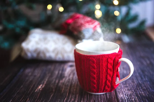 Taza roja de café o té de Navidad con vapor, galletas caseras de jengibre en una mesa de madera, dulces en el fondo — Foto de Stock
