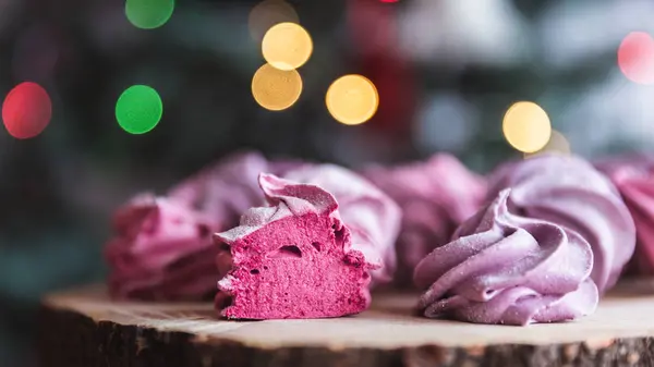 Close up of homemade cut pink zephyr or marshmallow in powdered sugar on wooden with abstract bokeh background. Black currant, blueberry marshmallows. — Stock Photo, Image