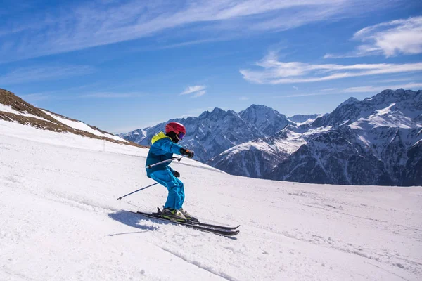 Little boy in blue and yellow ski costume skiing in downhill slope. Winter sport recreational activity — Stock Photo, Image