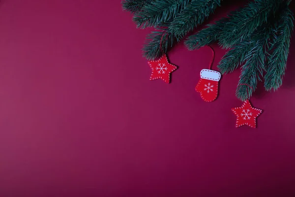 Weihnachtskomposition. Weihnachtsroter Holzschmuck, Tannenzweige auf rotem Hintergrund. flache Lage — Stockfoto