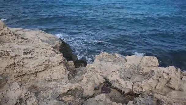 Хвилі котиться з шумом на кам'янистий берег і б'ється на берег. Прекрасний морський пейзаж . — стокове відео